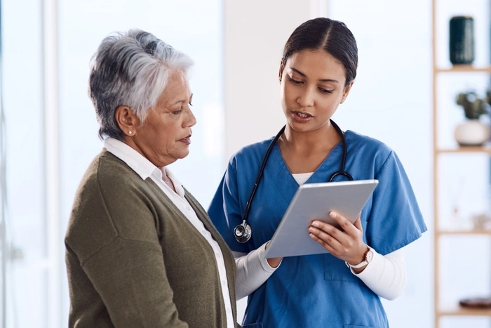 Shot of a young doctor using a digital tablet during a consultation with a senior woman.