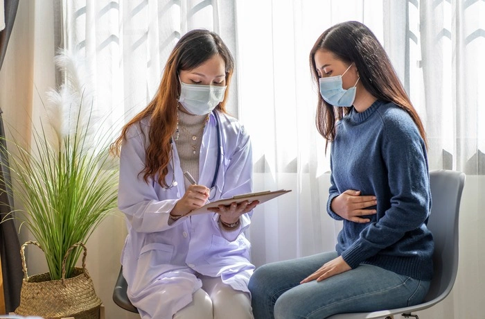 Asian doctor wears a uniform to examine the patient and wear a mask to consult and treat the disease.