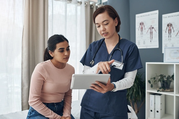 . Shot of a young female doctor talking to a patient in an office.