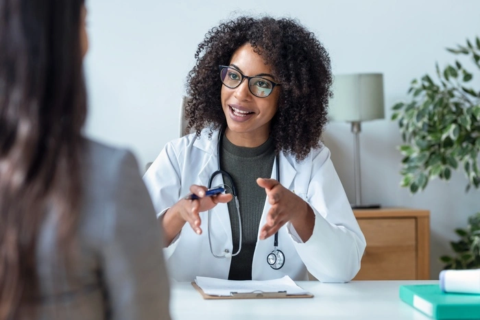 Shot of female doctor talking while explaining medical treatment to patient in the consultation.